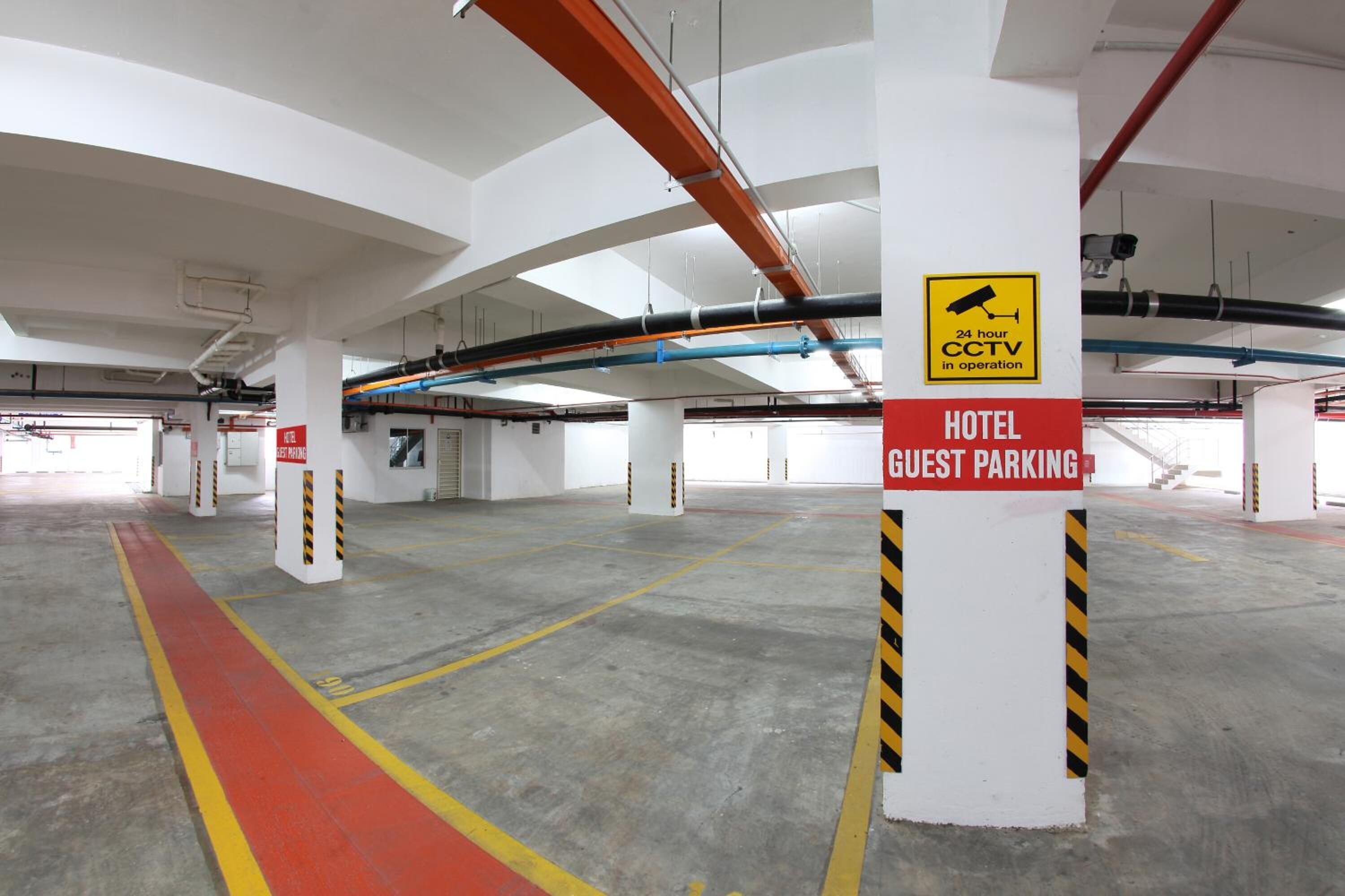 Ein Hotelparkplatz mit Videoüberwachung, Betonböden und tragenden Säulen.