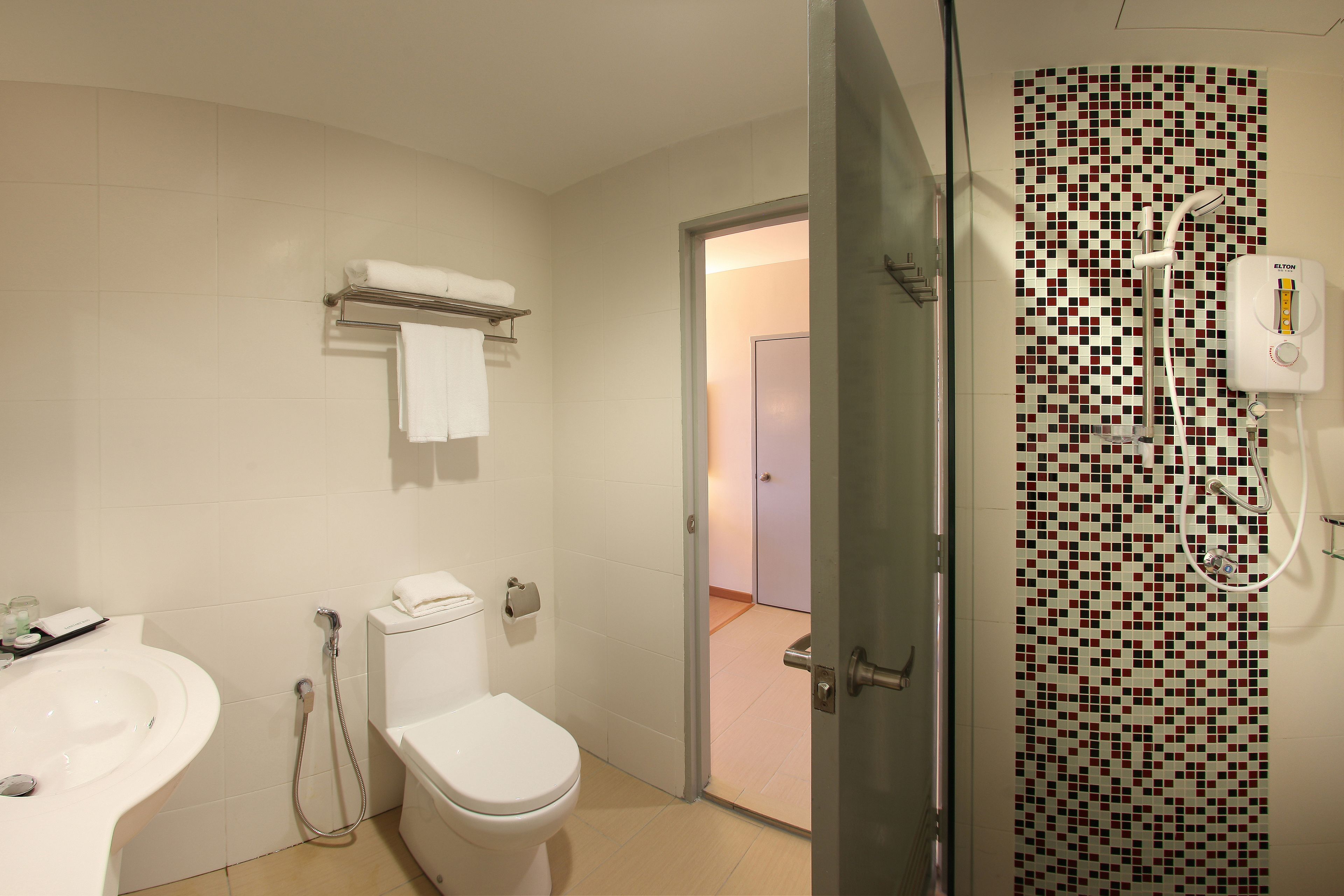 Un baño con inodoro, lavamanos y zona de ducha.