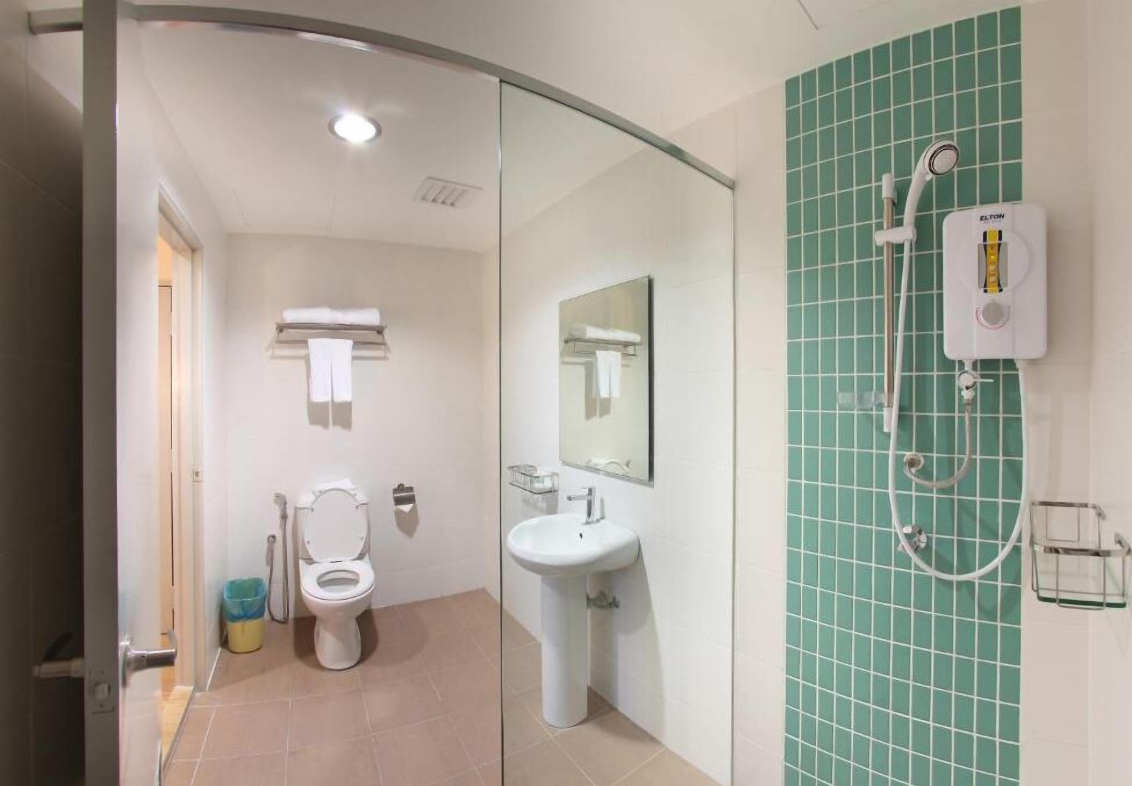 A modern bathroom with a toilet, sink, and shower.