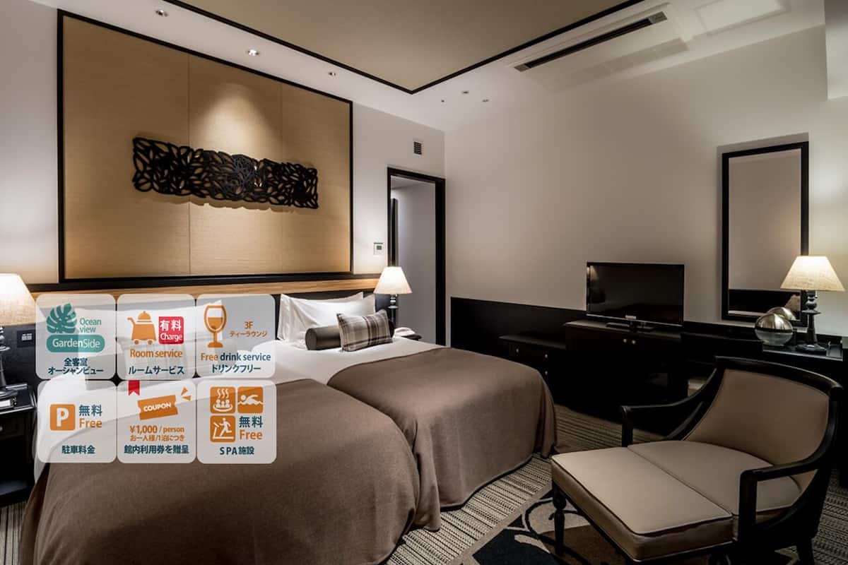 Een hotelkamer met twee bedden, een bureau, een televisie en een stoel.