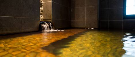 A room with a tiled floor, a water feature, and a window.