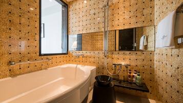 Um banheiro moderno com uma banheira grande, chuveiro e pia com amenities.