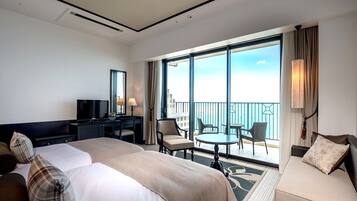 A hotel room with a large bed, a desk, a TV, and a balcony with a view.