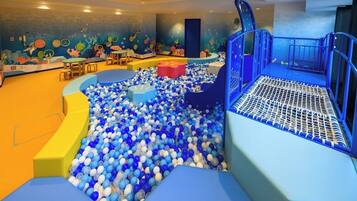A children's play area with a ball pit, seating, and a slide.