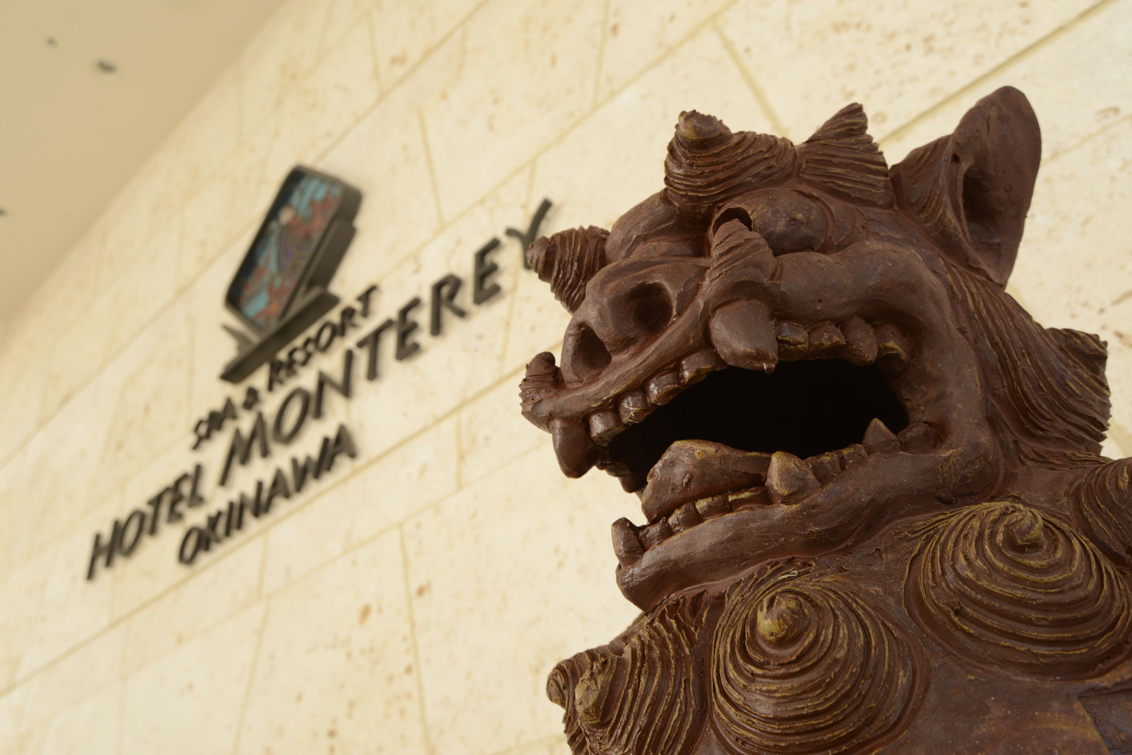 A detailed lion sculpture in front of a hotel sign.