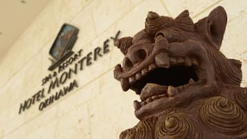 A detailed lion sculpture in front of a hotel sign.