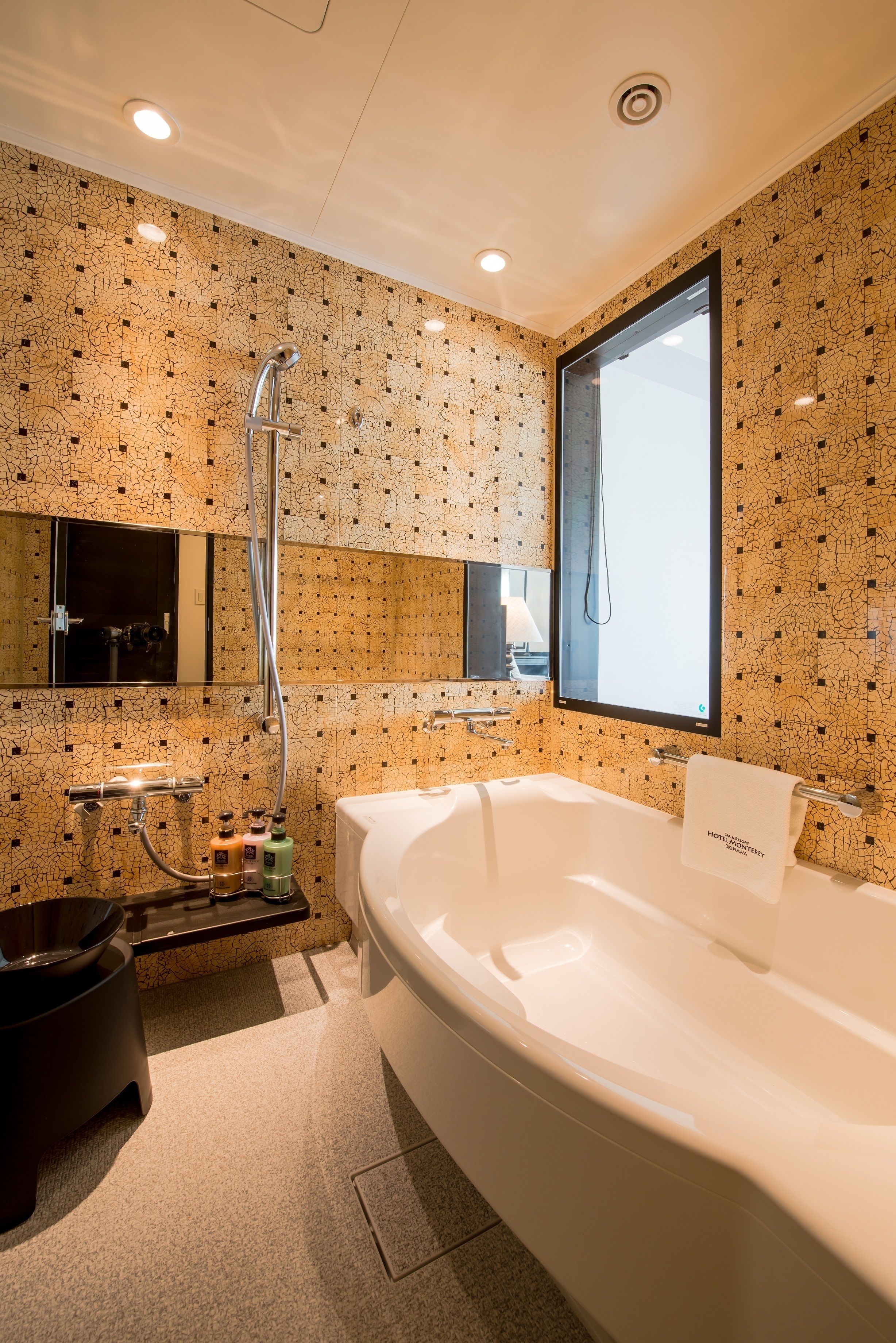 A modern bathroom with a large bathtub, a shower, and a mirror.