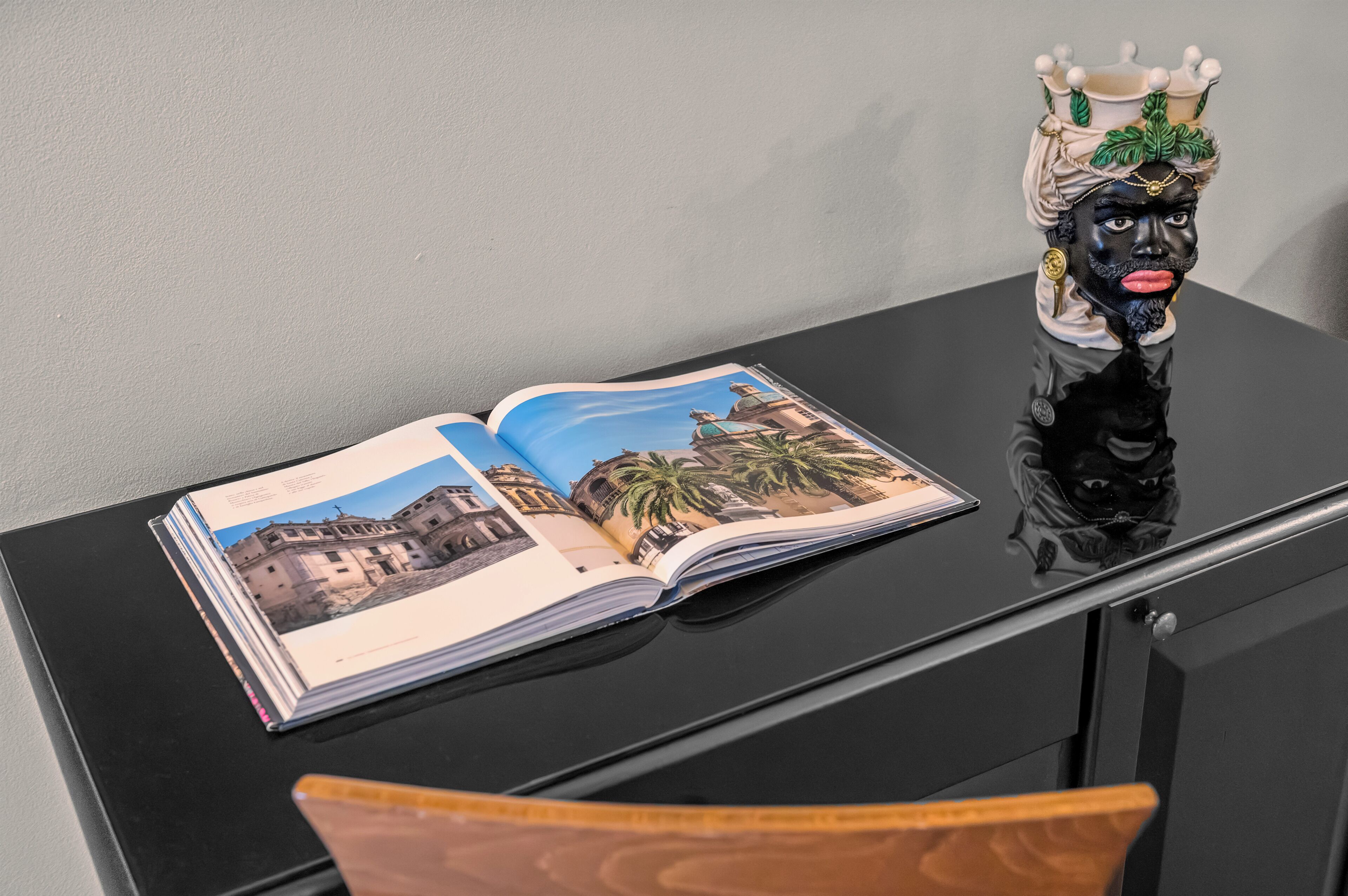 An open book with a photograph of a building on a black table.