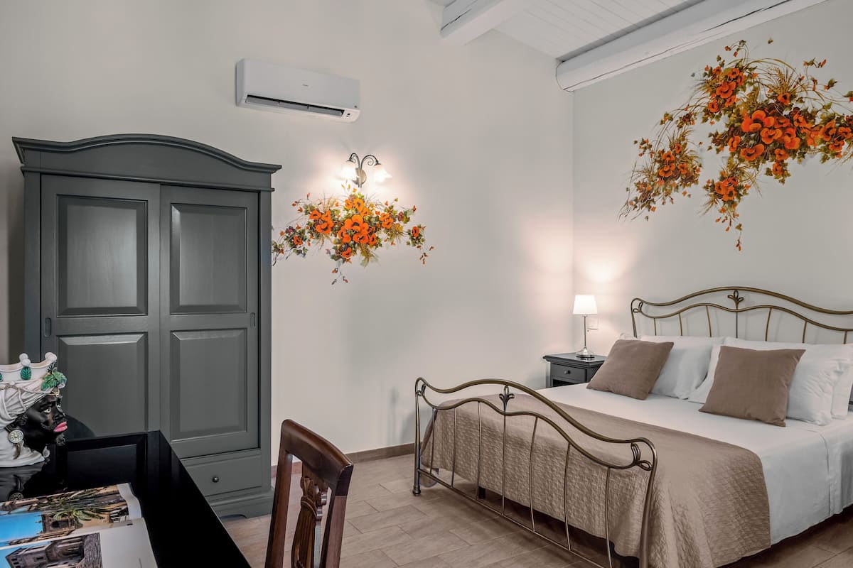 Un dormitorio con cama, mesita de noche, lámpara y armario.