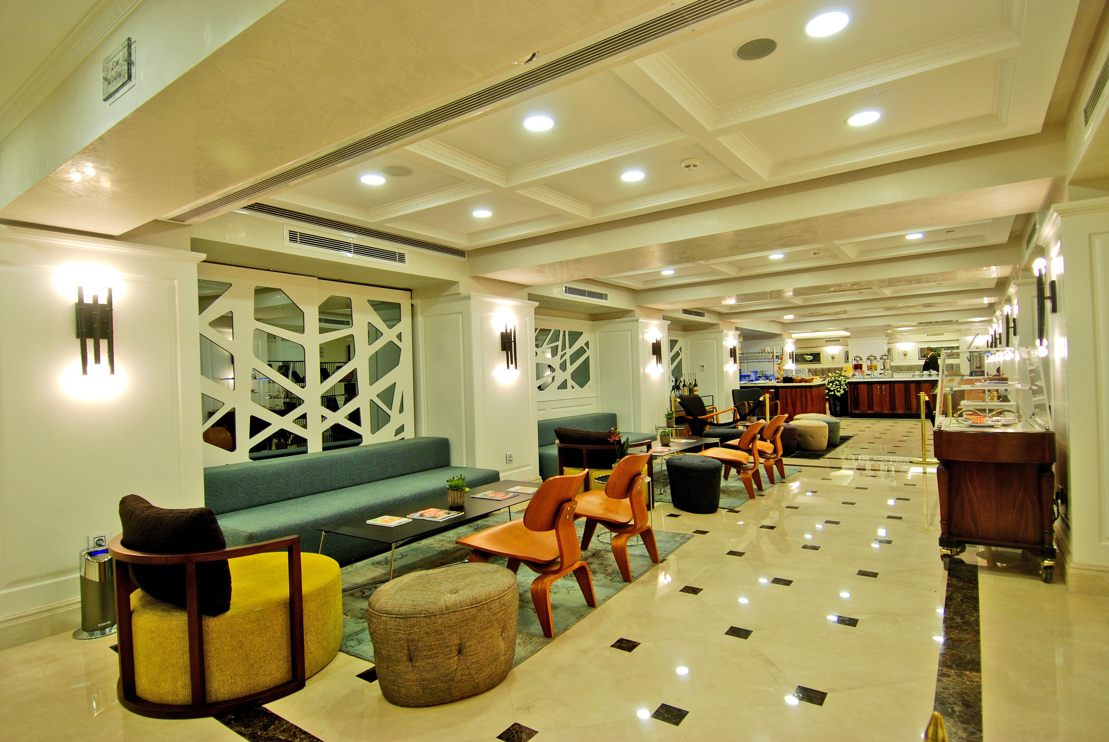 A spacious lobby with a central seating area, a reception desk, and a bar.