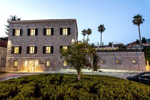 A stone building with multiple windows and a sign that reads "HOTEL SUPETAR".