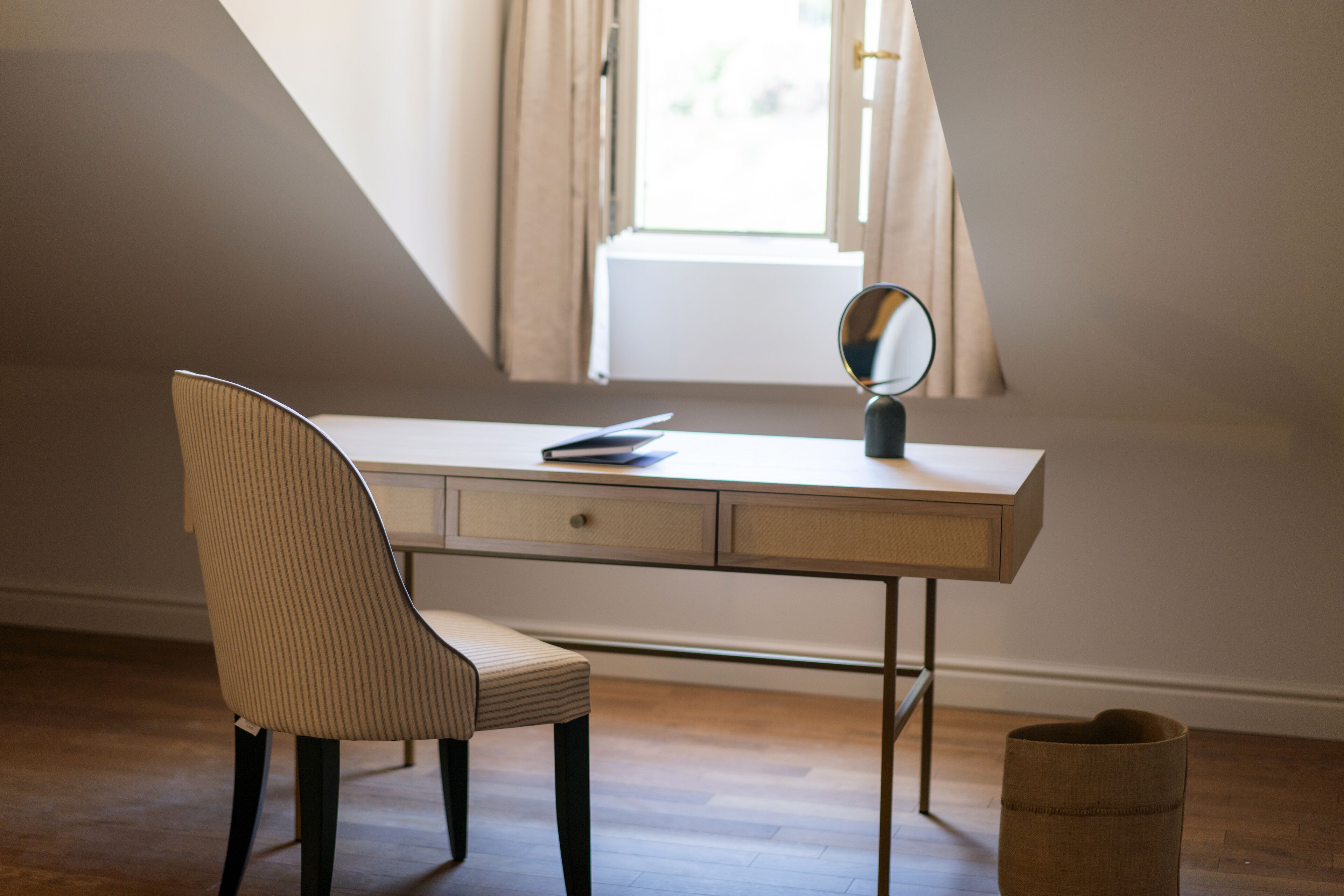 A study with a desk, chair, and a mirror.