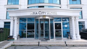 The exterior of the Asia City Hotel with a glass entrance, white columns, and a sign above the doors. - Asia City Hotel Istanbul (Istanbul)