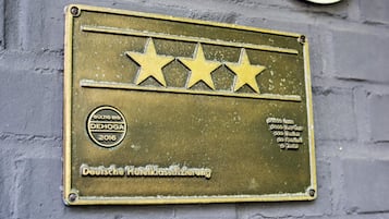 Una placa con tres estrellas y texto que indica una clasificación hotelera alemana de 2016.