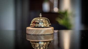 Een glanzend houten onderstel met een metalen koepelstructuur, vermoedelijk onderdeel van een hotel receptie.