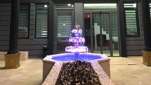 A building entrance with a decorative fountain and a well-maintained flower bed. - Mera Park Hotel (Antalya)
