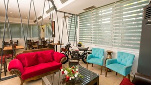 A modern living room with a red sofa, blue armchairs, and a glass coffee table. - Mera Park Hotel (Antalya)
