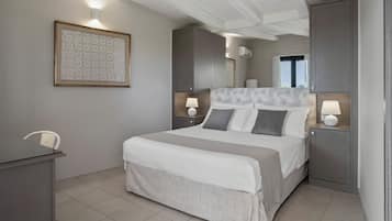 Quarto arrumado com uma cama, mesas de cabeceira, uma escrivaninha e uma obra de arte emoldurada na parede.