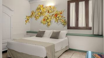 A bedroom with a bed, a window with curtains, and a wall with a floral mural.