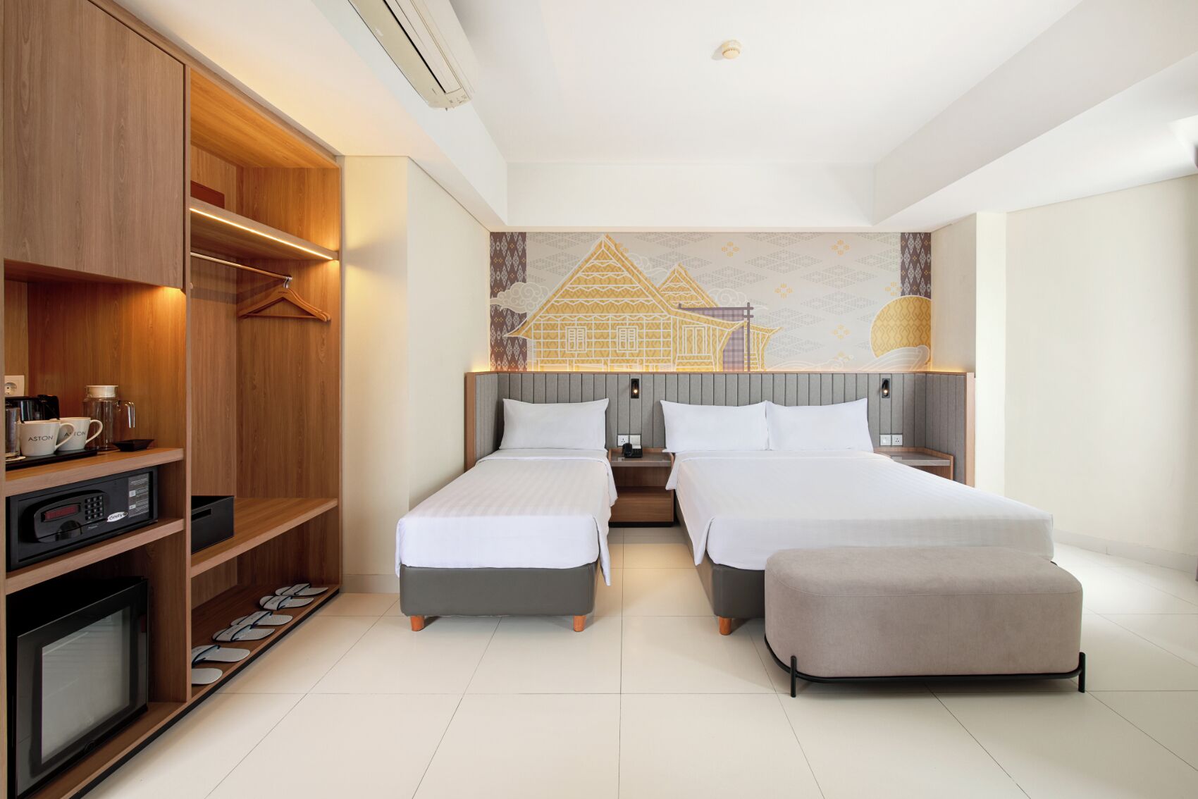 A hotel room with two beds, a wardrobe, a TV, and a coffee machine.