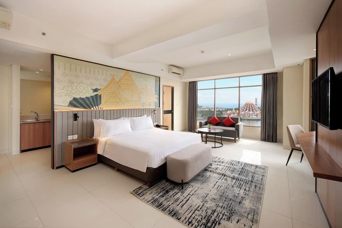 Een moderne hotelkamer met een groot bed, een bureau, een stoel en een televisie.