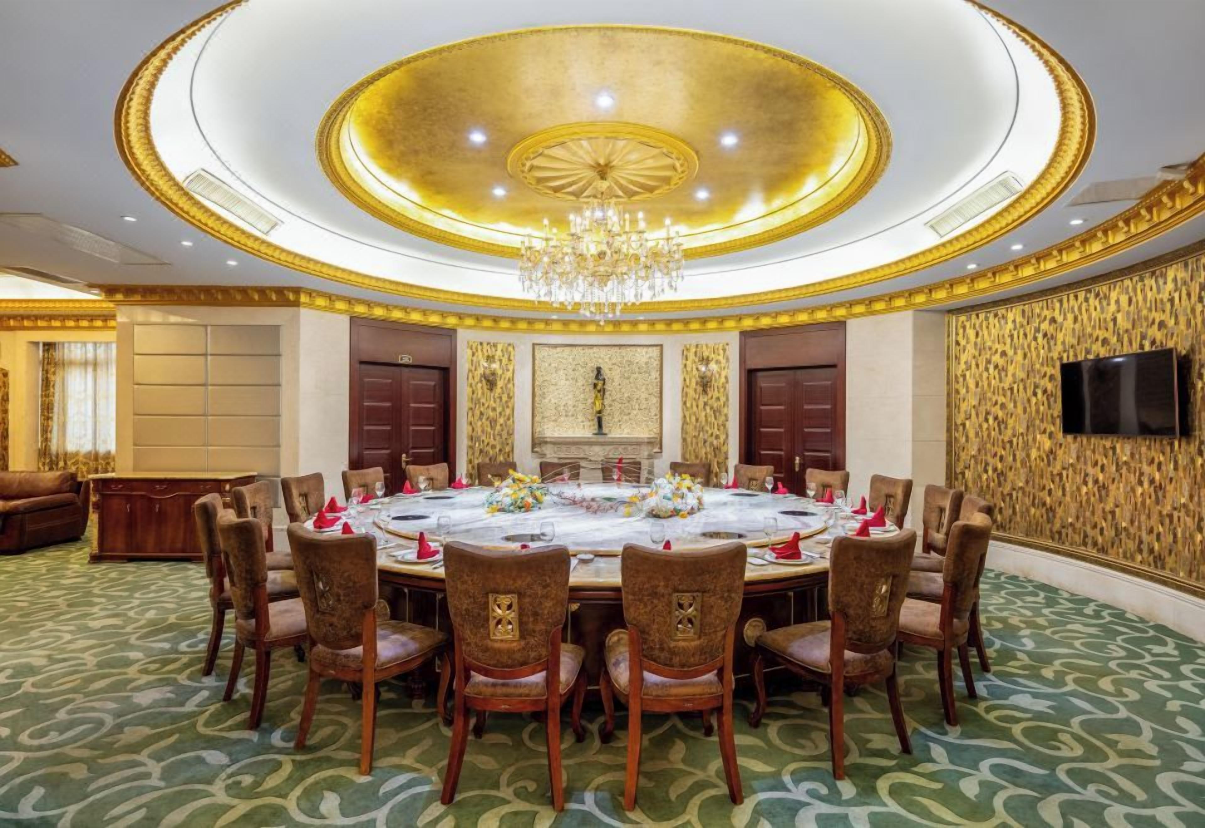 Un comedor formal con una mesa redonda, sillas y una araña.