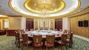 Un comedor formal con una mesa redonda, sillas y una araña.