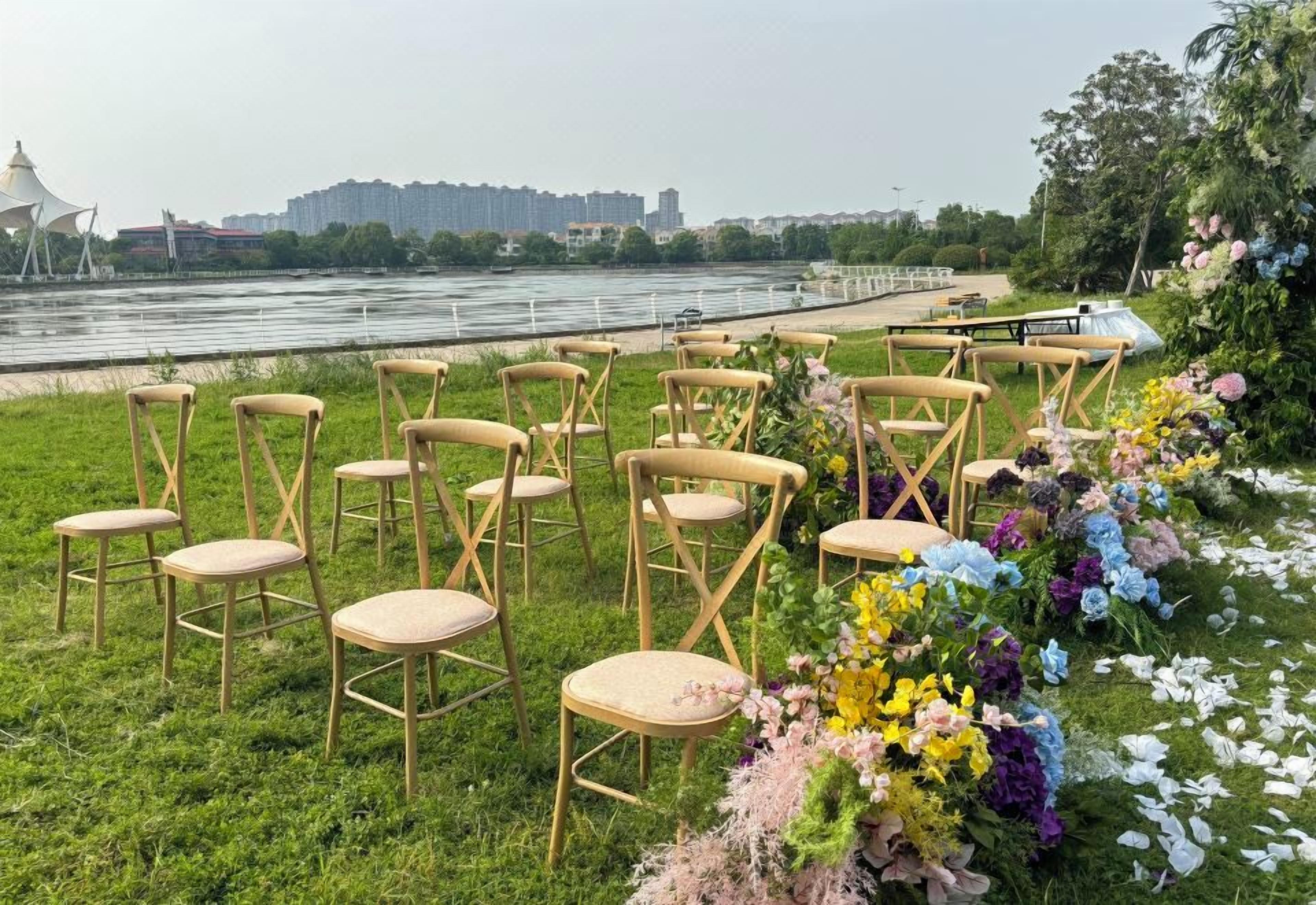 Des chaises disposées sur une pelouse pour créer un espace de détente en plein air, avec une rivière et des bâtiments de la ville en arrière-plan.