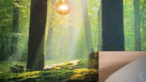 A bedroom with a bed, a round wooden stool, and a hanging light fixture. - B&B Antares (Bruges)