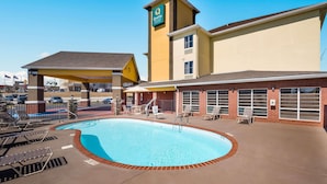 Et hotel med swimmingpool, udendørs siddepladser og et overdækket område.