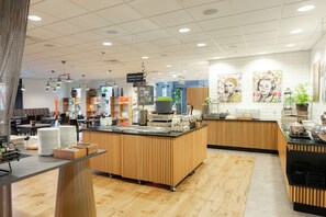 A modern café with wooden accents and a central counter. - Scandic Stavanger City (Stavanger)