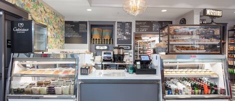 A bakery counter with a display case of pastries and a refrigerated section with beverages.