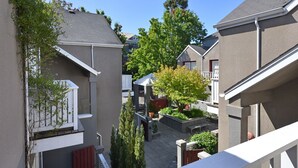 A residential area with multiple houses, a small garden, and a clear blue sky.