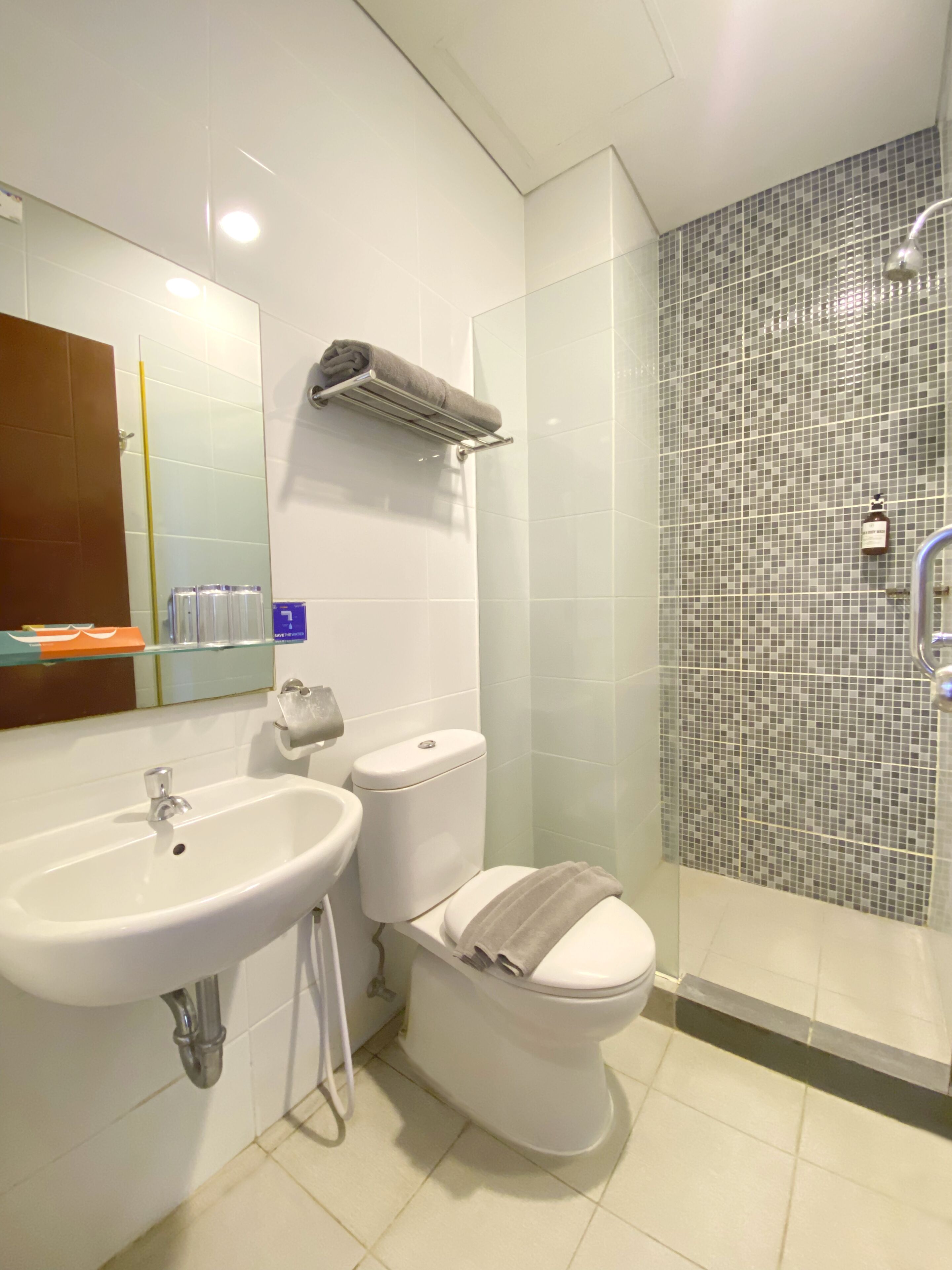 Un bagno moderno con lavandino bianco, WC e box doccia in vetro.