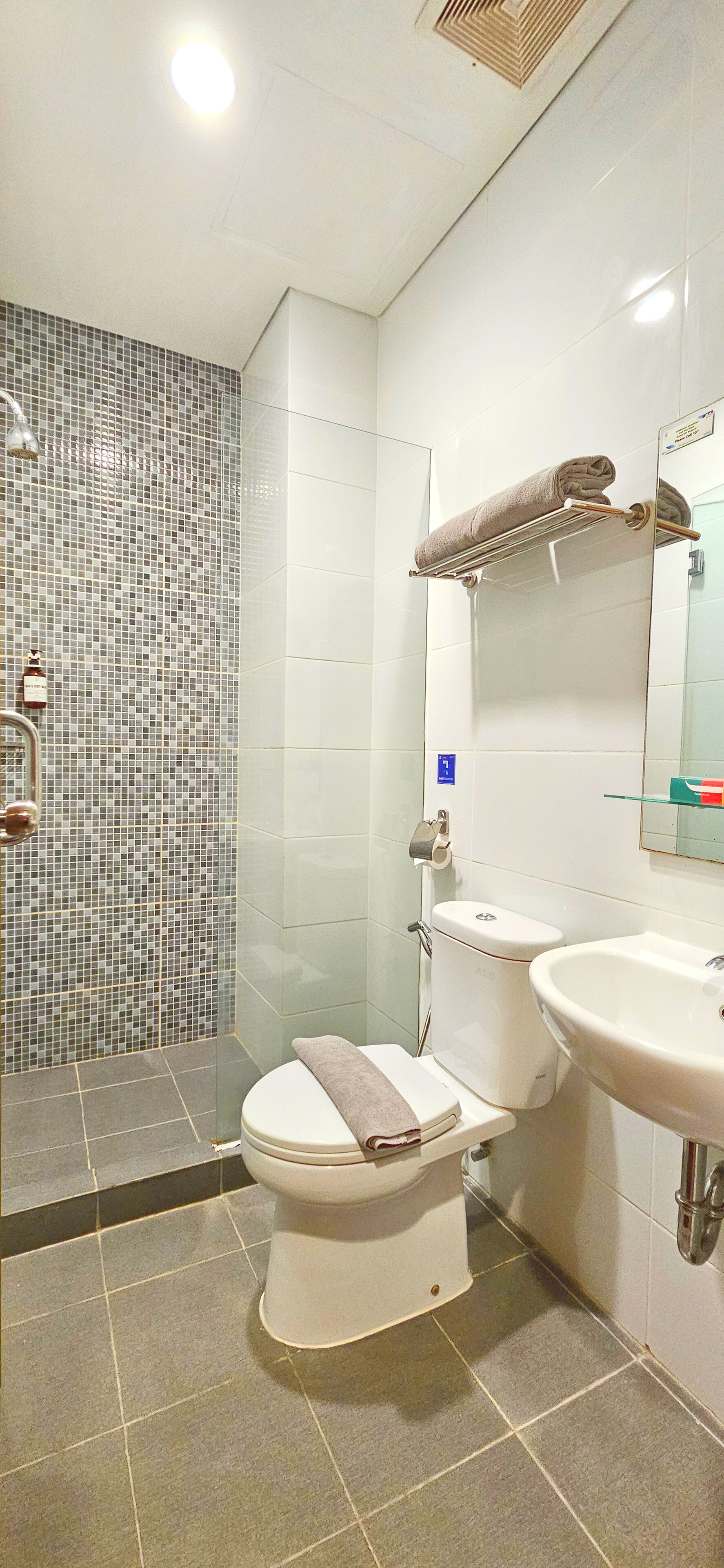 A bathroom with a shower, toilet, and sink.