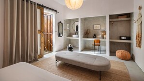 A modern bedroom with a large bed, a bench, a chair, and a hanging light fixture. - DREAMCATCHER by DW - ADULTS ONLY (San Juan)