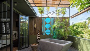 A modern bathroom with a freestanding bathtub, a small round stool, and a pair of slippers on the floor. - DREAMCATCHER by DW - ADULTS ONLY (San Juan)