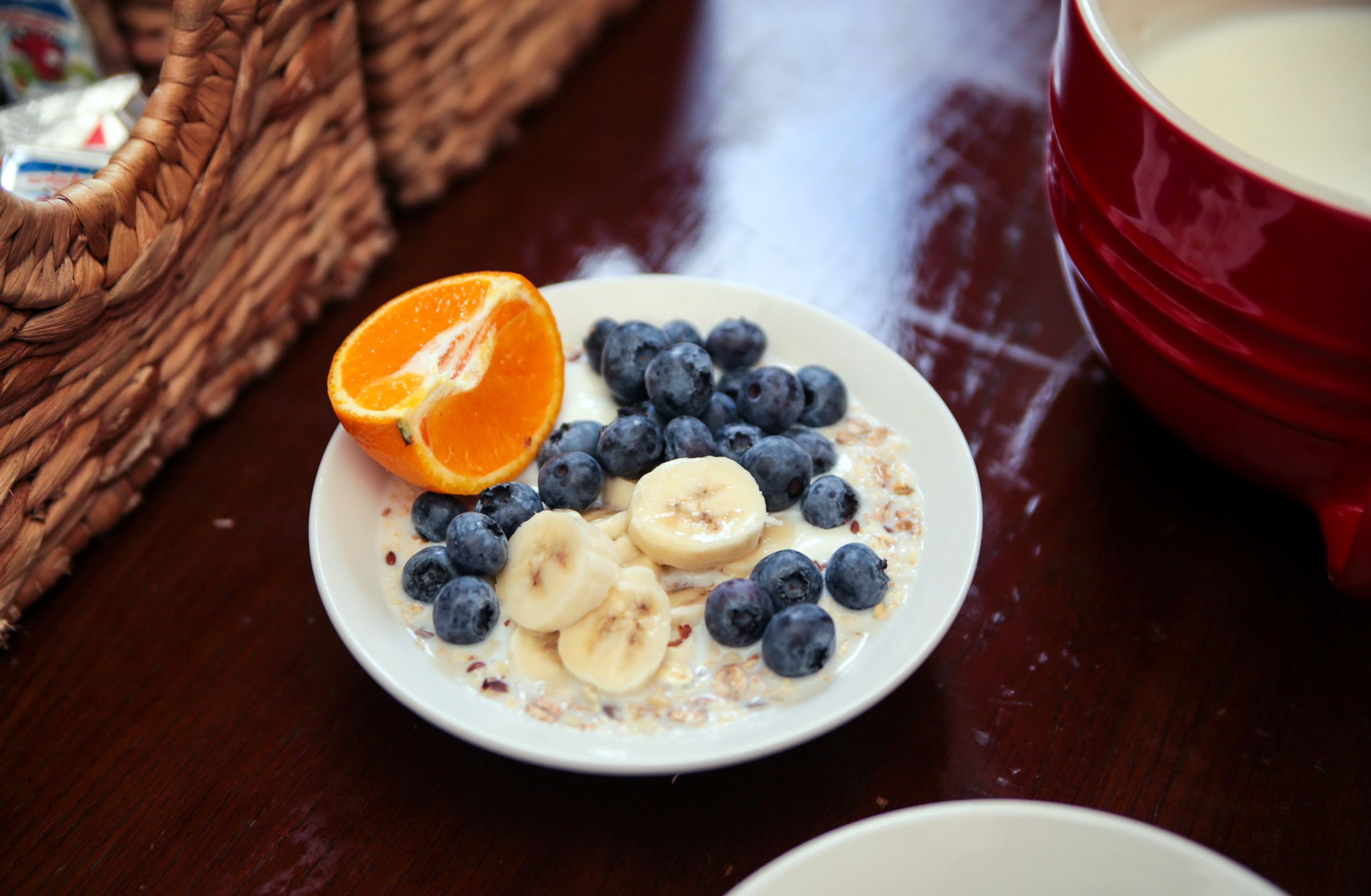 A plate of oatmeal with blueberries and banana slices on a wooden table.