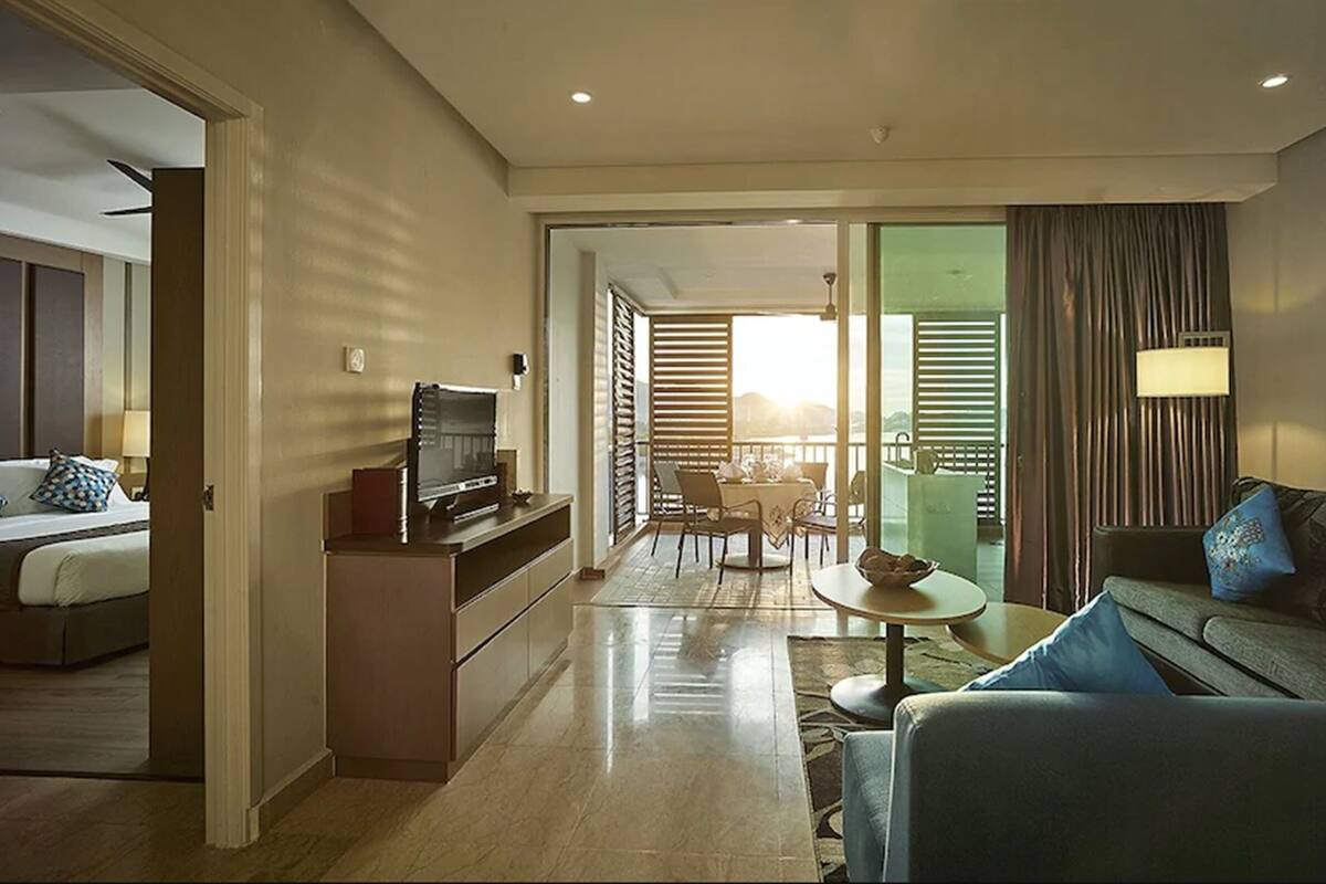 Une chambre d’hôtel équipée d’un lit, d’une télévision, d’un bureau, d’un canapé et d’un balcon avec vue.