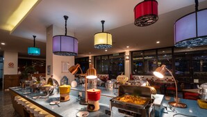 Un espace buffet avec différents stands de nourriture, une machine à café et un panneau indiquant qu’il s’agit d’une zone non-fumeur.