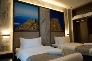 A hotel room with two beds, marble walls, and a large poster of a mountain.