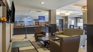 A hotel lobby with seating areas, a breakfast bar, and a reception desk. - Holiday Inn Express & Suites Indio - Coachella Valley by IHG (Indio)