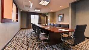 A conference room with a large table, six chairs, and a projector screen. - Holiday Inn Express & Suites Indio - Coachella Valley by IHG (Indio)