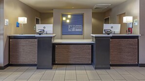 A hotel reception area with two HP computer stations, a Holiday Inn Express sign, and a no-smoking sign. - Holiday Inn Express & Suites Indio - Coachella Valley by IHG (Indio)
