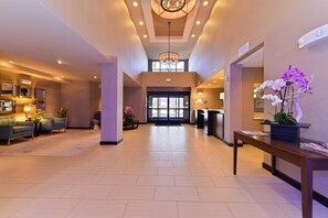 A spacious lobby with a reception desk, seating area, and a chandelier. - Holiday Inn Express & Suites Indio - Coachella Valley by IHG (Indio)