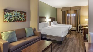 A hotel room with a bed, a sofa, a desk, and a painting on the wall. - Holiday Inn Express & Suites Indio - Coachella Valley by IHG (Indio)