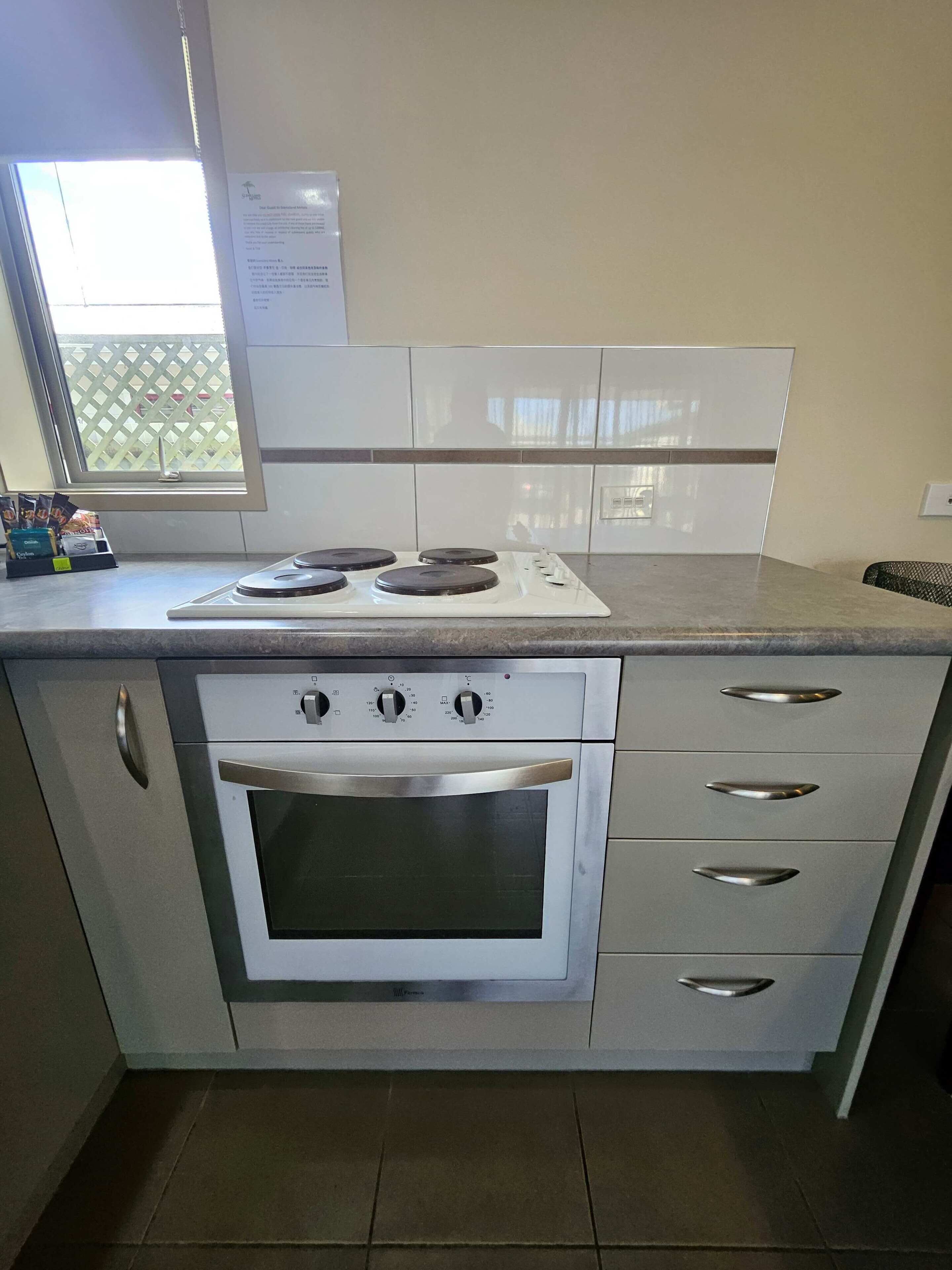 A kitchen with a built-in oven, a stovetop, and a window with a view.