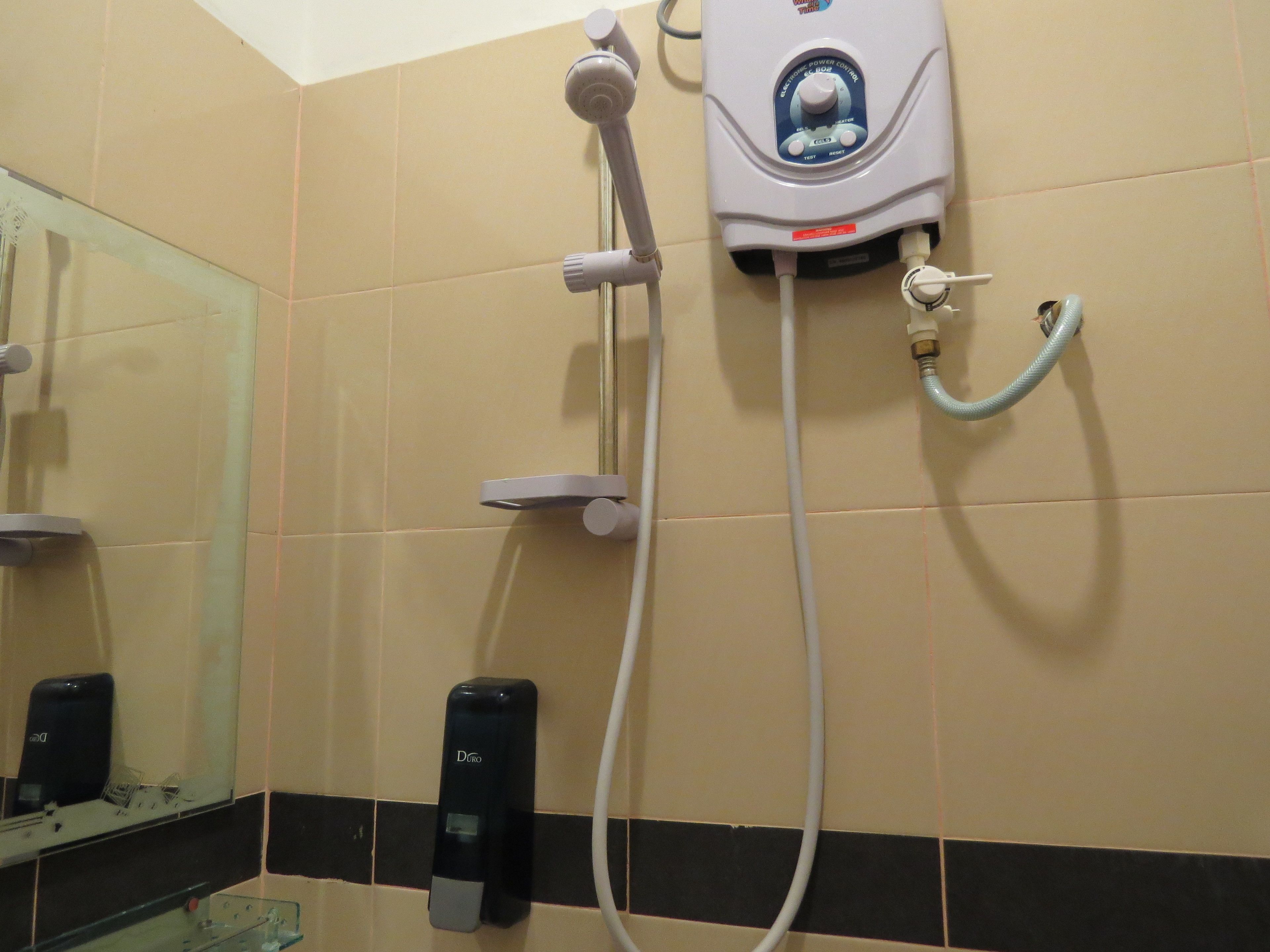 Ein Badezimmer mit Dusche, Handtrockner und Seifenspender.