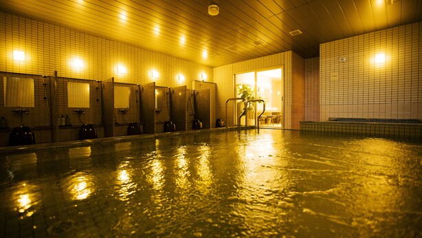 A swimming pool with tiled walls and a wooden ceiling, equipped with multiple changing rooms and a bench area. - Sakura Terrace (Kyoto)