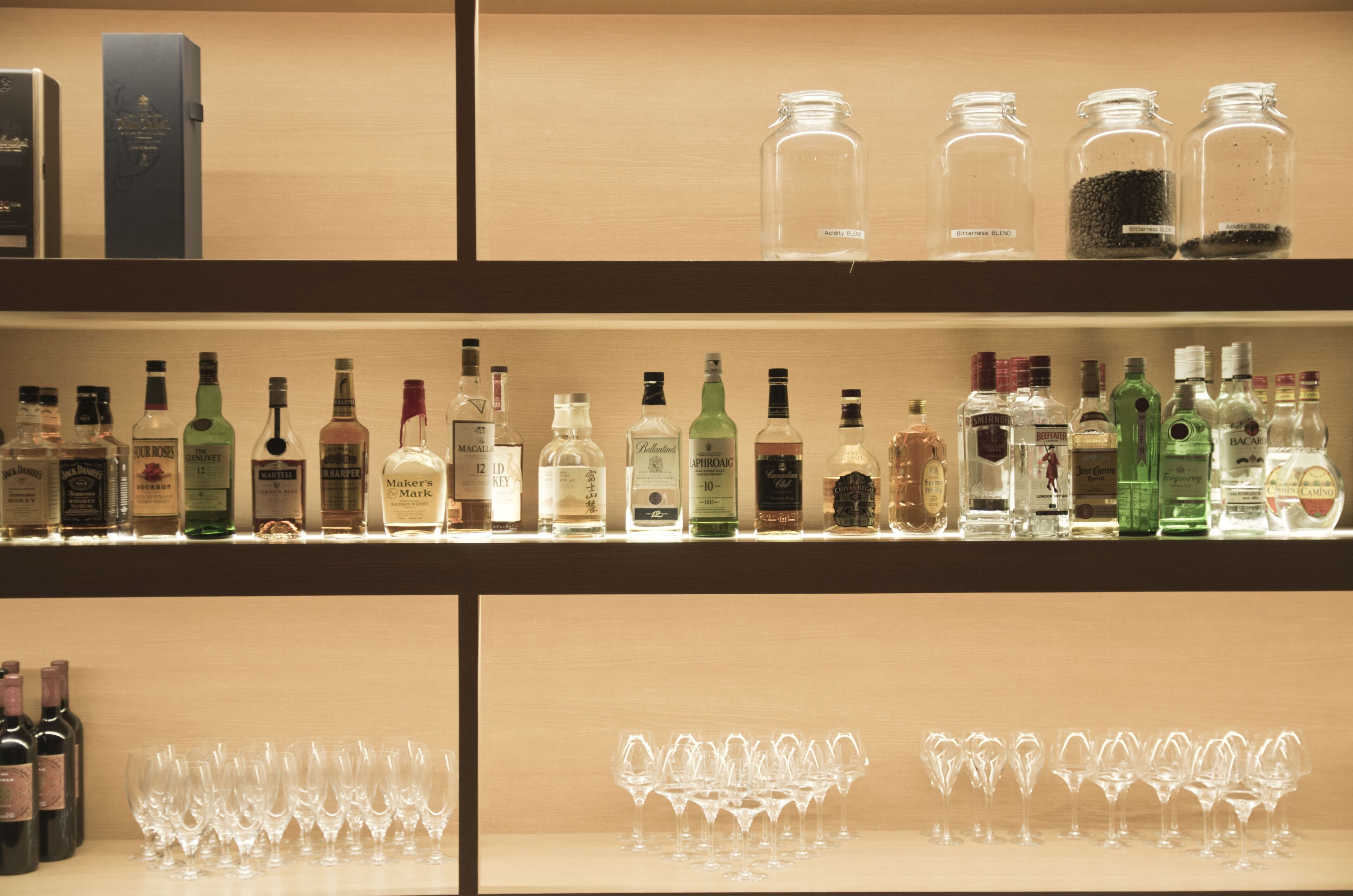 A bar area with shelves of liquor bottles and glasses.